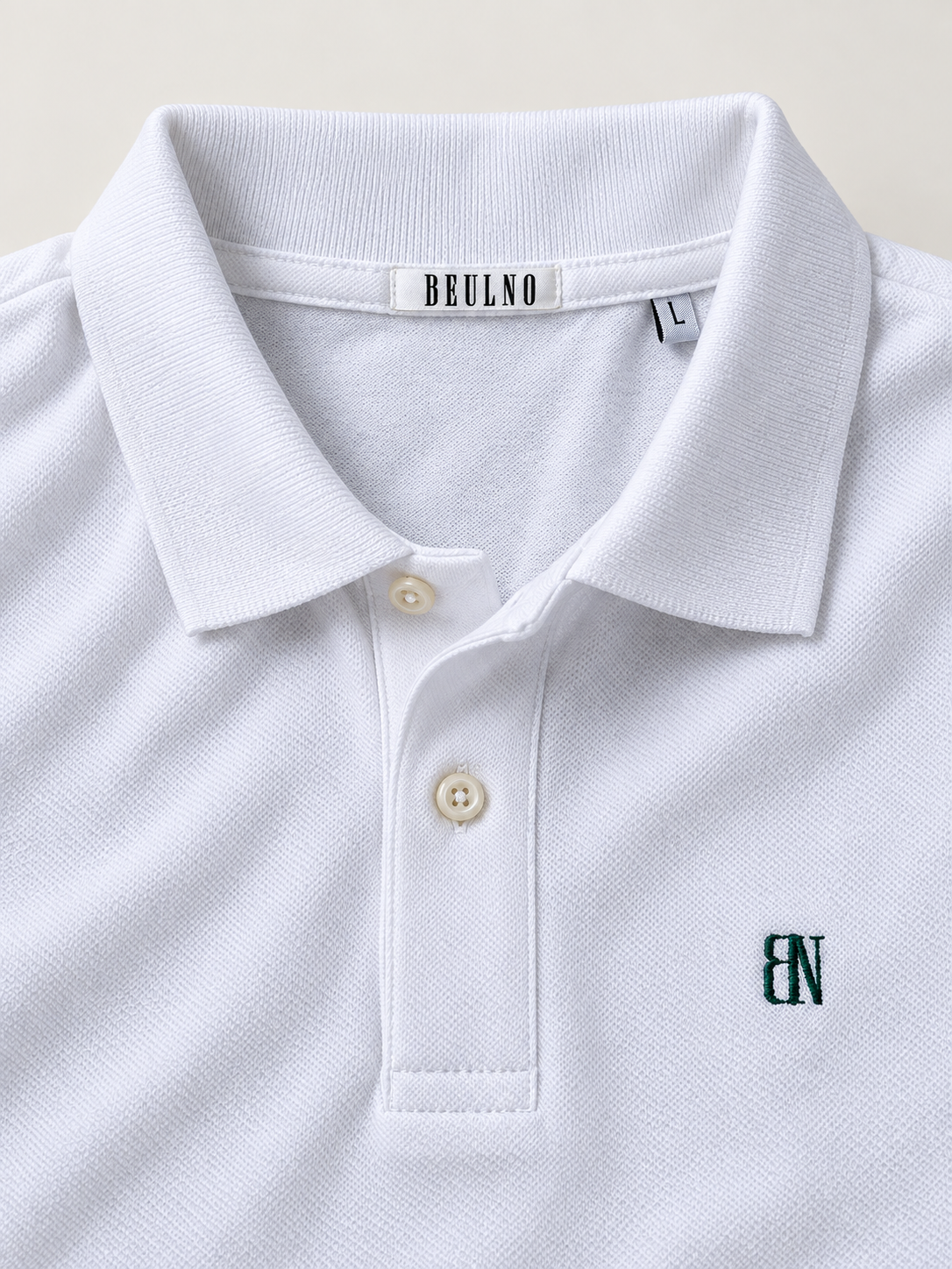 Essential Long Sleeve Polo — Signature em Branco — detalhe da gola, etiqueta interior e bordado